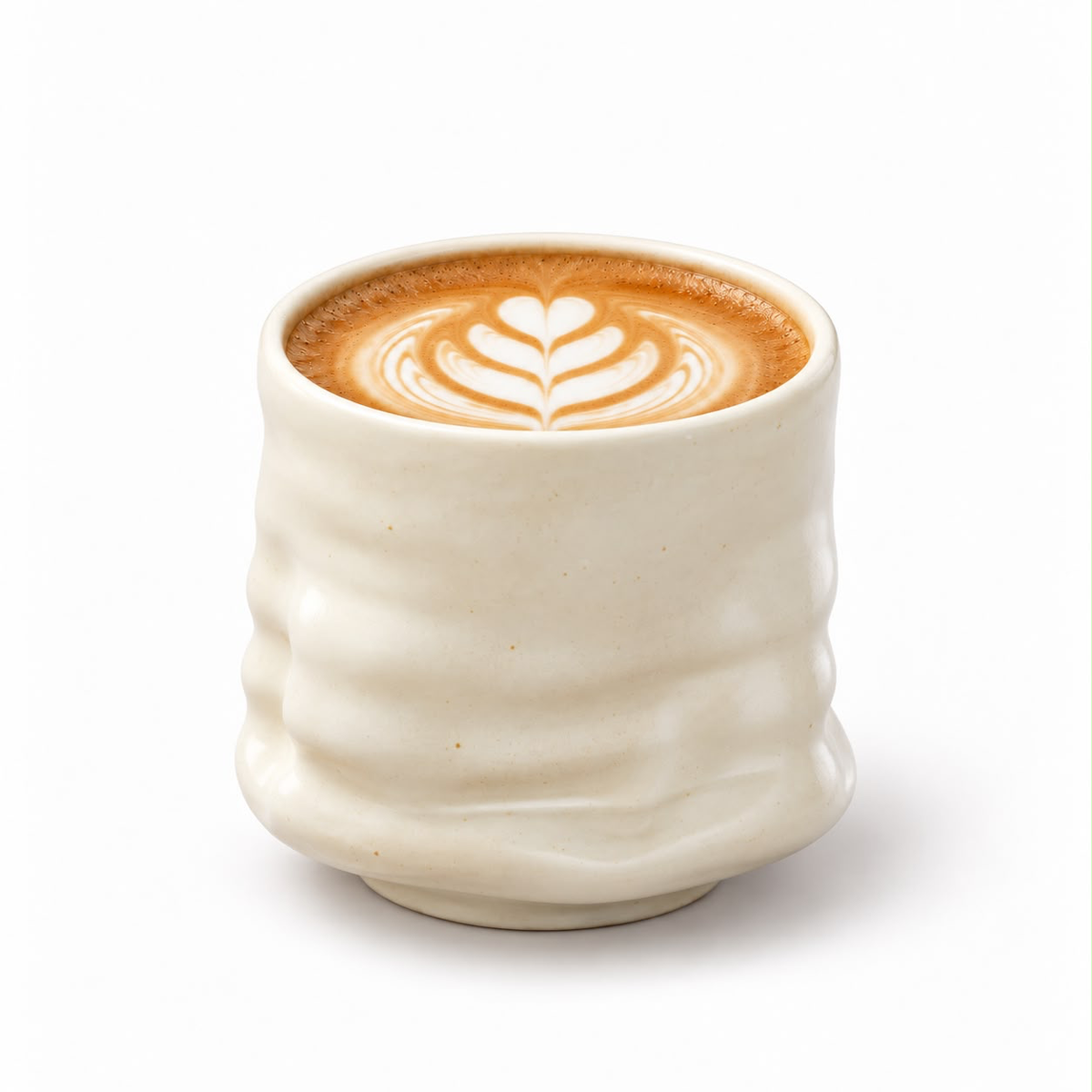 Cremefarbener Keramikbecher mit welliger Oberfläche und Latte Art